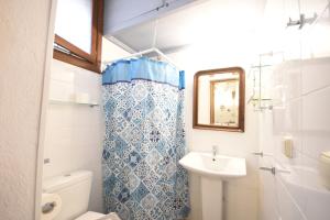 a bathroom with a sink and a toilet and a mirror at Masì House in Rhodes Town