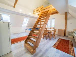 a kitchen and dining room with a ladder in a tiny house at Chalupa Pod Smědavou in Weissbach