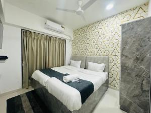 a bedroom with a large bed with white sheets at Astha Powai Service Apartment in Mumbai