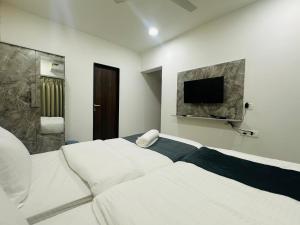 Postel nebo postele na pokoji v ubytování Astha Powai Service Apartment