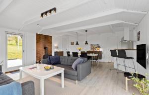 een woonkamer met een bank en een tafel bij 3 Bedroom Amazing Home In Tranekr in Tranekær