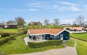 une maison bleue avec un toit rouge dans un champ dans l'établissement 3 Bedroom Amazing Home In Tranekr, à Tranekær