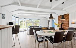 uma sala de jantar e sala de estar com mesa e cadeiras em 3 Bedroom Amazing Home In Tranekr em Tranekær