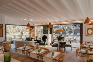 a restaurant with tables and chairs and a fireplace at Boutique Hotel Villa Salvador - Adults Only by Fimedhotels in Cadaqués