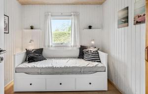 uma cama branca num quarto com uma janela em Awesome Home In Vggerlse With Kitchen em Bøtø By