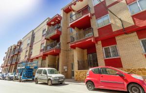 zwei Autos vor einem Gebäude geparkt in der Unterkunft Nice Apartment In San Pedro Del Pinatar in San Pedro del Pinatar + 16 Fotos