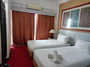a hotel room with two beds and a window at Chloe Seaview Homestay in Tanjung Bungah