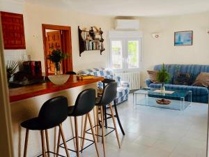 cocina y sala de estar con bar y sillas en Belvilla by OYO Casa Alegria, en Cumbre del Sol