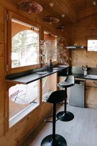 a kitchen with black counter stools and a window at Charming Tiny House in LʼIsle-sur-la-Sorgue