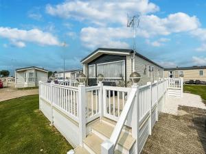 una casa con una valla blanca y un porche en Modern 6 Berth Caravan With Wifi At Martello Beach In Essex Ref 28008pm, en Clacton-on-Sea