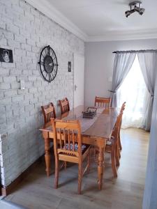 ein Esszimmer mit einem Holztisch und Stühlen in der Unterkunft Jan's Cottage in Centurion