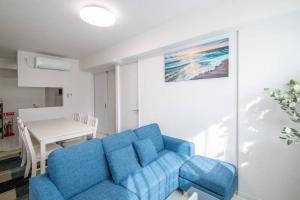 ein blaues Sofa im Wohnzimmer mit einem Tisch in der Unterkunft オーシャンズスイート 東京ディズニーリゾートマリンバルコニー303室 in Tokio