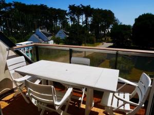 a white table and chairs sitting on a balcony at Appartement Quiberon, 3 pièces, 5 personnes - FR-1-478-75 in Quiberon