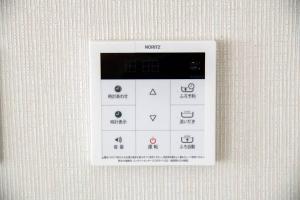 東京的住宿－オーシャンズスイート 東京ディズニーリゾートマリンバルコニー303室，墙上的白色遥控器,上面有符号