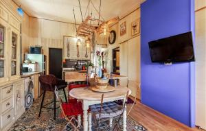 uma sala de jantar com uma mesa e uma parede azul em Nice Home In Robion With House A Panoramic View em Robion en Luberon