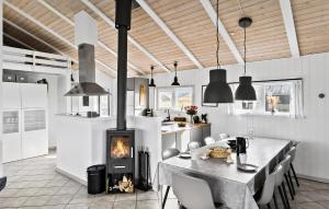 a kitchen with a table and a stove in a room at Amazing Home In Løkken With Sauna in Løkken
