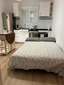 a bedroom with a bed and a kitchen at Casa con WiFi, patio y garaje privado in Alcalá de Guadaira