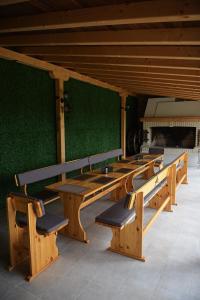 a row of wooden benches in front of a green wall at Вила Релакс in Pamporovo +62 photos