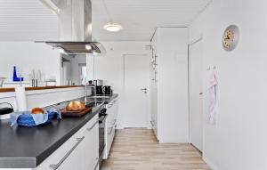 Una cocina con gabinetes blancos y una encimera negra. en Gorgeous Home In Svendborg With Wifi, en Svendborg