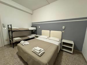 una camera con due letti e asciugamani di Hotel Serafini a Rimini