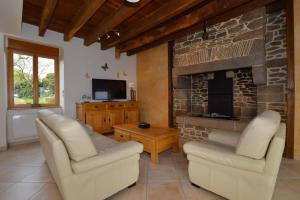 a living room with two chairs and a fireplace at De dartagnan in La Fontenelle