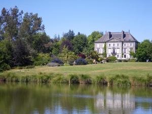a large house on a hill next to a body of water at De dartagnan in La Fontenelle