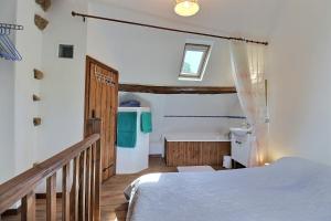 a bedroom with a bed and a bathroom at La petite maison bleue in Les Portes du Coglais