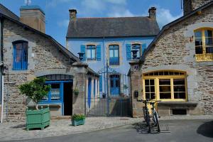 a bicycle parked in front of a brick house at La petite maison bleue in Les Portes du Coglais +8 photos