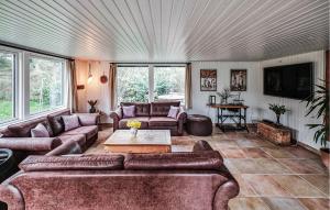a living room with couches and a table at Four-Bedroom Holiday Home In Vaggerlose in Marielyst