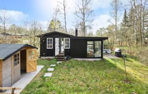 een zwart tiny house in een yard bij 1 Bedroom Stunning Home In Tikb in Tikøb