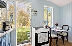 a kitchen with a stove and a table and a window at 1 Bedroom Beautiful Home In Tikøb in Tikøb