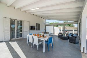 ein Esszimmer und ein Wohnzimmer mit Tisch und Stühlen in der Unterkunft Villa Dell'Ulivo con piscina privata By Sicily Home Solutions in Alcamo