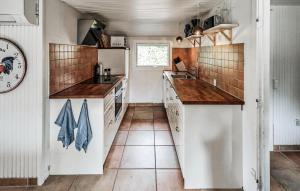 a kitchen with white cabinets and wooden counter tops at Four-Bedroom Holiday Home In Vaggerlose in Marielyst