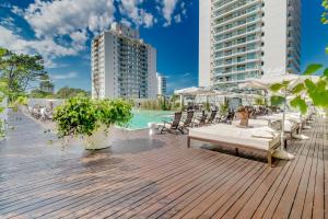 a deck with chairs and a pool and buildings at Oceana Suites en Yoo, con piscina interior climatizada in Punta del Este