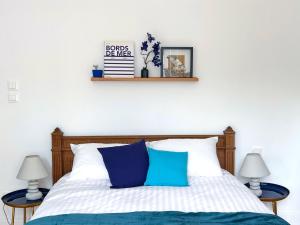 a bedroom with a bed with blue and white pillows at KYPRYS - Villa 1930 - Wimereux in Wimereux
