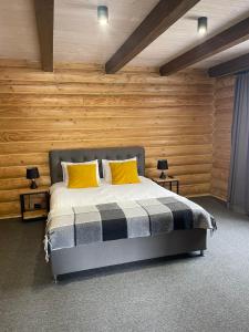 ein Schlafzimmer mit einem Bett mit zwei gelben Kissen in der Unterkunft Вілла Розмарія in Jaremtsche