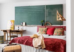 a bedroom with a red bed and a green chalkboard at Boutiquehotel Stadthalle in Vienna