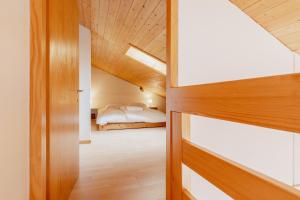 - une chambre avec un lit et un plafond en bois dans l'établissement Logement avec une vue envoûtante sur la vallée, à Crans-Montana