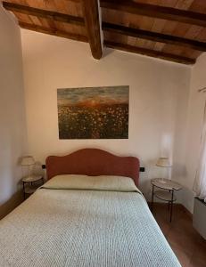 a bedroom with a bed and a painting on the wall at Agriturismo Casa Alle Vacche in San Gimignano