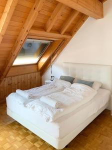a white bed in a room with an attic at Charming penthouse with veranda in the center of Brig in Brig