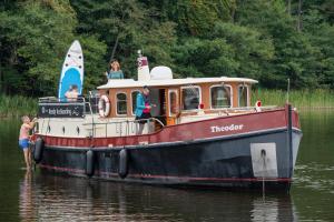 un grupo de personas en un barco en el agua en Kuhnle-Tours Hafendorf Müritz, en Rechlin