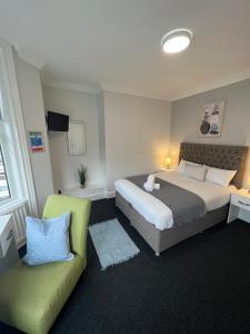 Habitación de hotel con 2 camas y sofá en Alexander Hotel, en Whitley Bay
