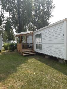 a mobile home with a porch and a deck at Mobilhome L'Oasis Camping le Clos Cottet in Angles