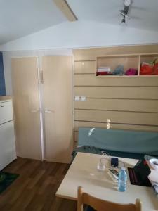 a room with a bed and a table and a closet at Mobilhome L'Oasis Camping le Clos Cottet in Angles