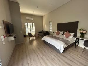 1 dormitorio con 1 cama grande y TV en The Wantage Suites, en Johannesburgo