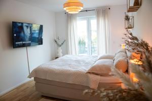 a bedroom with a bed and a tv on the wall at Fairmieten: Exklusive Suite I Terrasse I Parkplatz in Bielefeld