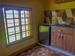 een keuken met een roestvrijstalen koelkast en een raam bij Finca cafetera turística in Buesaco