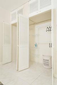 1 dormitorio con paredes blancas y puertas blancas en Pines Serenity Suites in Kingston 6, en Kingston