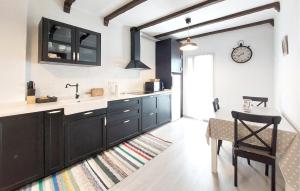 a kitchen with black cabinets and a sink and a table at Stunning Apartment In Peñíscola in Peñíscola