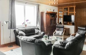 ein Wohnzimmer mit 2 Ledersesseln und einem Tisch in der Unterkunft Ferienhaus Am Rodelberg H in Priborn